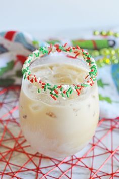 a drink with sprinkles on the rim sitting on top of a table