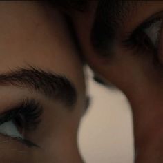 two people with their eyes close to each other