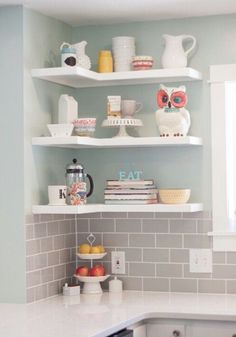 a kitchen with white cabinets and shelves filled with dishes