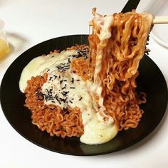 a black plate topped with noodles and sauce