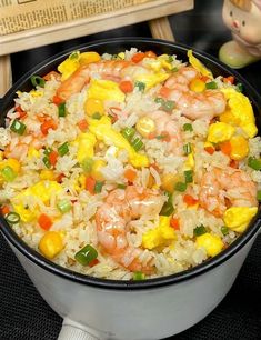 a bowl filled with rice and shrimp on top of a table