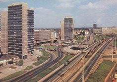 an aerial view of a city with train tracks in the foreground and cars on the other side