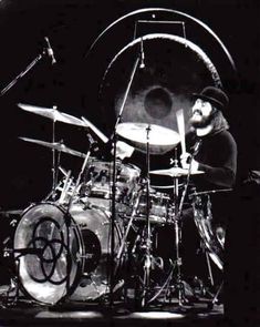 a man sitting behind a drum kit on stage