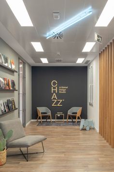 the interior of an office with chairs and bookshelves on the wall, along with wooden flooring