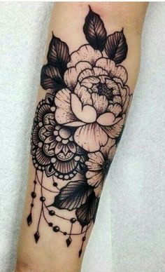 a black and white flower tattoo on the arm