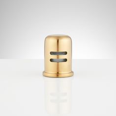 a small gold object sitting on top of a white table