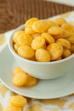 a white bowl filled with cornflakes sitting on top of a table next to a plate