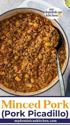 a large pot filled with meat and vegetables on top of a white counter next to a spoon