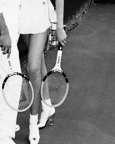 a man and woman holding tennis racquets on a court