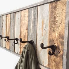 a coat rack made out of wood and metal hooks