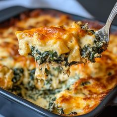 a spoonful of spinach casserole is being lifted from the casserole dish