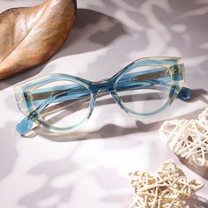 These frames boast a graceful cat-eye silhouette that exudes timeless elegance. The seamless blend of dual colors adds a touch of intrigue, creating a visual symphony that captivates the beholder. With a palette of enchanting hues, these glasses become a canvas for self-expression, allowing you to embrace your unique style.Weight: 34.3 gFrame Shape: Cat Eye, OvalFrame Color: BlueFrame Material: AcetateRim Type: Full RimSpring Hinge: NoAdjustable Nose Pads: NoWeight: 34.3 gLens Width: 49 mmBridge Width: 20 mmTemple Length: 145 mmFrame Width: 135 mmLens Height: 39 mm Retro Blue Cat Eye Sunglasses, Elegant Blue Tinted Cat Eye Sunglasses, Elegant Blue Cat Eye Sunglasses, Blue Cat Eye Sunglasses With Glass Lenses, Blue Cat Eye Sunglasses With Gradient Lenses, Eye Silhouette, Blue Glasses, Glasses Online, Eyewear Design