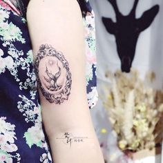 a woman's arm with a deer tattoo on the left side of her arm