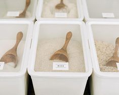 four bins with wooden spoons and rice in them