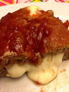 a piece of meatloaf covered in sauce and cheese