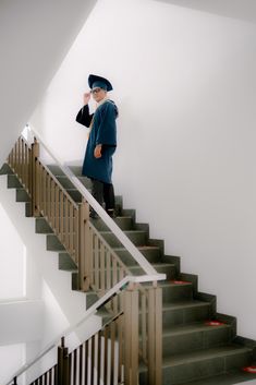 a woman standing on top of a set of stairs next to a stair case in a white room