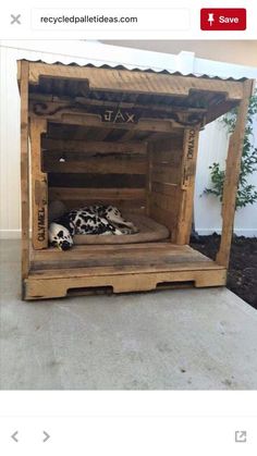 a dog bed made out of pallet wood with a dalmatian sleeping in it