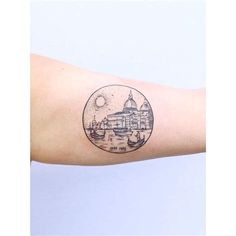 a tattoo on the arm of a person with a cityscape in the background