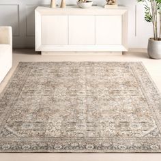 a living room with white furniture and a large rug on the floor in front of it