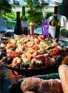 a table topped with lots of food next to bottles of wine and other items on top of it