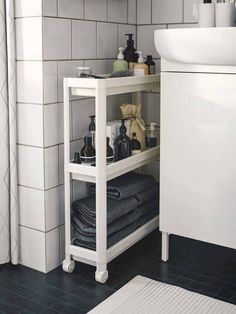 a bathroom with a sink, towel rack and toiletries on the shelf in front of it