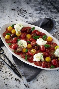 a white plate topped with tomatoes and cheese