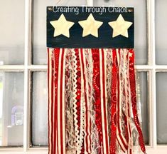 an american flag with stars hanging from it's side in front of a window