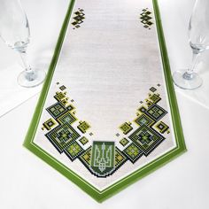 a green and white table runner with two wine glasses