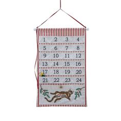 a calendar hanging from a red string on a white wall, with numbers and animals