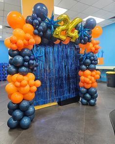 the balloon arch is decorated with blue and orange balloons