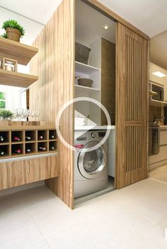 a washer and dryer in a room with open shelves on the wall next to each other