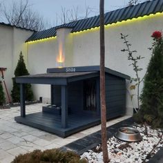 the outside of a building with a dog house and fire place in front of it