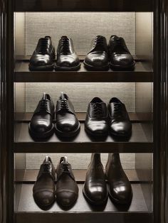 several rows of men's dress shoes on shelves