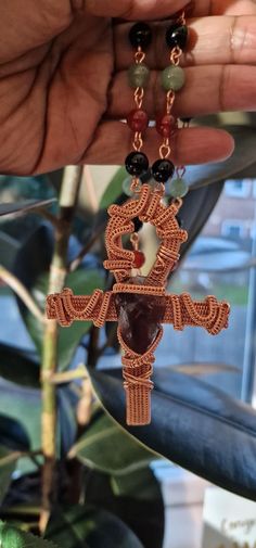 This stunning copper wire-wrapped Ankh pendant, featuring a radiant Amethyst point, hangs gracefully from a handcrafted chain adorned with Carnelian, Aventurine, and Obsidian gemstones. The Ankh, a powerful symbol of life and spiritual energy in ancient Egypt, is beautifully complemented by the healing vibrations of these carefully chosen crystals. Amethyst is renowned for its spiritual properties, offering protection, enhancing intuition, and promoting inner peace. Combined with Carnelian for v Handmade Artisan Ankh Jewelry, Artisan Ankh Jewelry For Gift, Ankh Pendant, Crystals Amethyst, Chakra Racine, Healing Vibrations, Cleansing Crystals, Crystals Healing Properties, Amethyst Point