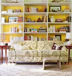 a living room filled with furniture and bookshelves covered in lots of bookcases