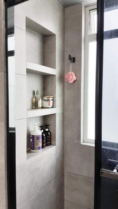 a bathroom with a toilet and shelves in it