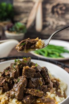 a spoon full of beef and mashed potatoes