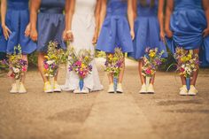 a group of women in blue dresses standing next to each other with flowers on their feet