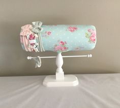 This unique headband holder will help you organize and display your favorite headbands, hair bows, hair ties and other accessories. The bolster is designed with a delicate pattern of pink roses on a pale blue  with white dots background fabric. This holder can be custom ordered.  If you would rather choose another fabric from the fabric options page, please put that fabric choice in the "notes to seller section" at checkout. Fabric option link:  https://www.etsy.com/listing/837867739/fabric-options?ref=shop_home_active_1&frs=1 There are painted wooden dowels with finial ends extending 12 inches across to hang bracelets, hair accessories, etc. The bolster is 13 inches in length. The bolster has a 16-inch circumference The height of the organizer from the bottom of the base to the top of the White Dots Background, Dots Background, Hair Bow Organizer, Unique Headband