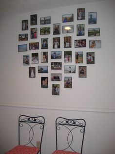 two red chairs sitting in front of a white wall with pictures on the wall above them