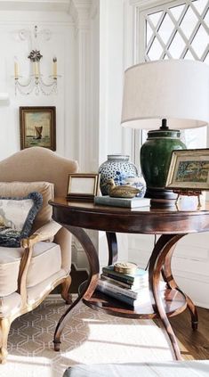 a living room filled with furniture and a lamp on top of a wooden coffee table