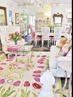 a living room filled with furniture and a chandelier above a glass top table