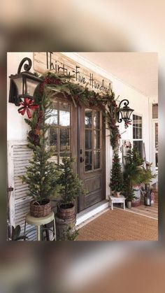 the front door is decorated for christmas with wreaths and pine trees on display in pots