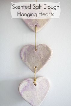 three hearts hanging on a wall with a sign that says scented salt dough hanging hearts