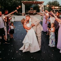 a bride and groom are dancing with sparklers in the air