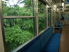 an empty train car with trees outside the windows