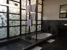 a bathroom with a bathtub, mirror and towel rack in it's corner