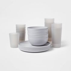 a stack of white plates and cups sitting next to each other