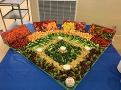 a large platter filled with lots of different types of vegetables and fruits on top of a blue table cloth