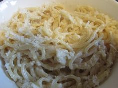 some noodles are in a white bowl on a table